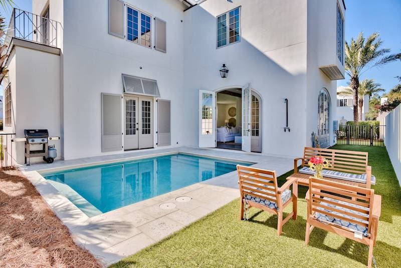 Clean guest-ready pool framed by polished landscaping and seating.